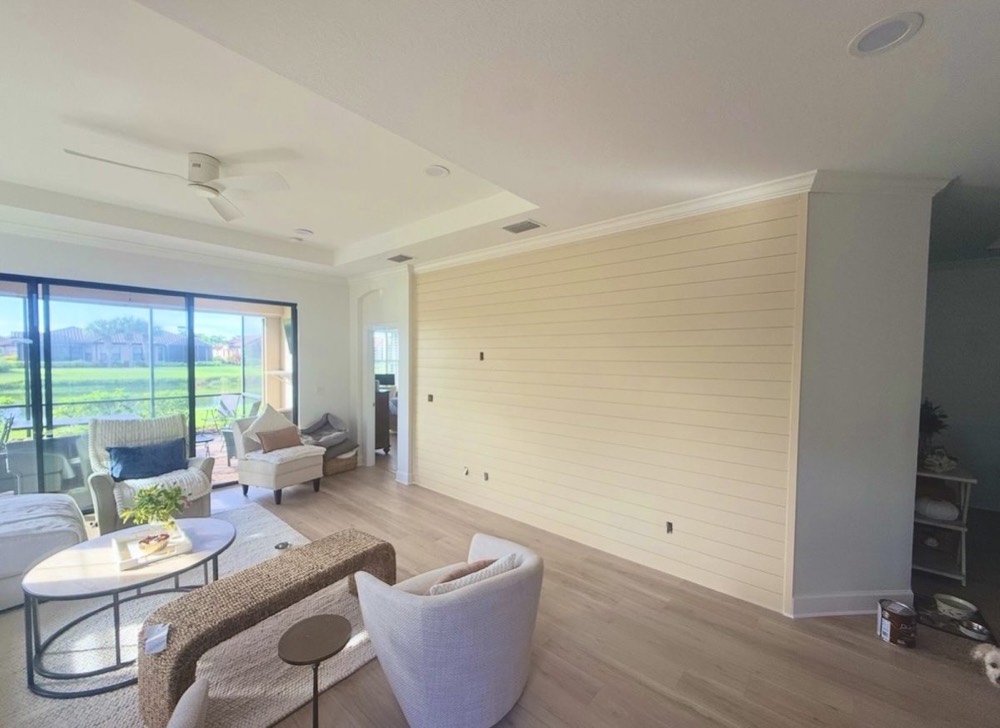 Painted cream shiplap accent wall in a coastal living room